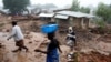 FILE - People walk past houses damaged in the aftermath of Tropical Cyclone Freddy in Blantyre, Malawi, on March 17, 2023. Meteorologists and officials in Malawi warned the nation on Dec. 13, 2024, that Tropical Cyclone Chido could bring similar heavy rain and flooding.