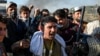 FILE - Supporters of jailed former Prime Minister Imran Khan's Pakistan Tehreek-e-Insaf party shout slogans while holding gear snatched from police during their march toward Islamabad demanding Khan's release, in Hasan Abdal, Nov. 25, 2024.