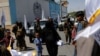 An Afghan woman with her son walks among Taliban supporters on the second anniversary of the fall of Kabul on a street near the US embassy in Kabul, Afghanistan, August 15, 2023. (Reuters/Ali Khara)