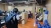 FILE - In this photo provided by the Philippine National Police Anti-Cybercrime Group, police walk in an office they raided in Las Pinas, Philippines, June 27, 2023. Gangs have forced thousands in Southeast Asia into participating in online scams.