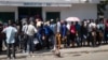 FILE - Haitians wait outside an immigration office to apply for a passport, in Port-au-Prince, Haiti, Jan. 10, 2023. President Joe Biden had announced an expansion of humanitarian parole on Jan. 5 for Cubans, Haitians, Venezuelans and Nicaraguans.