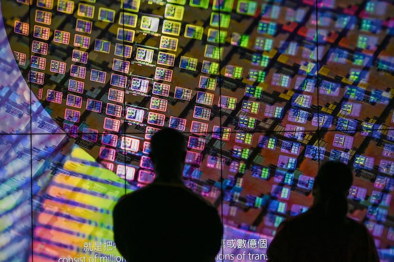 Visitors watch a wafer shown on screens at the Taiwan Semiconductor Manufacturing Company (TSMC) Renovation Museum at the Hsinchu Science Park in Hsinchu, Taiwan, on July 5, 2023.