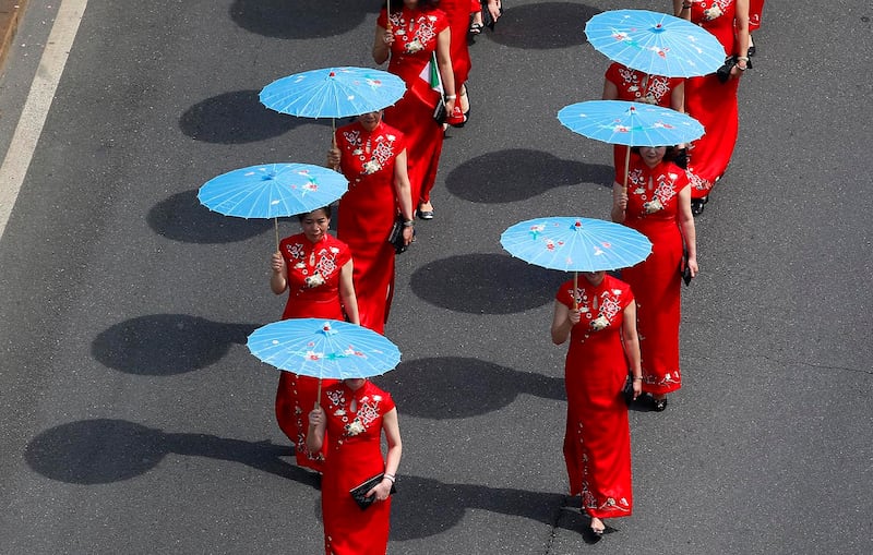 A group of Chinese girls marches in downtown Milan, Italy, May 20, 2017, to support migrants\' rights.