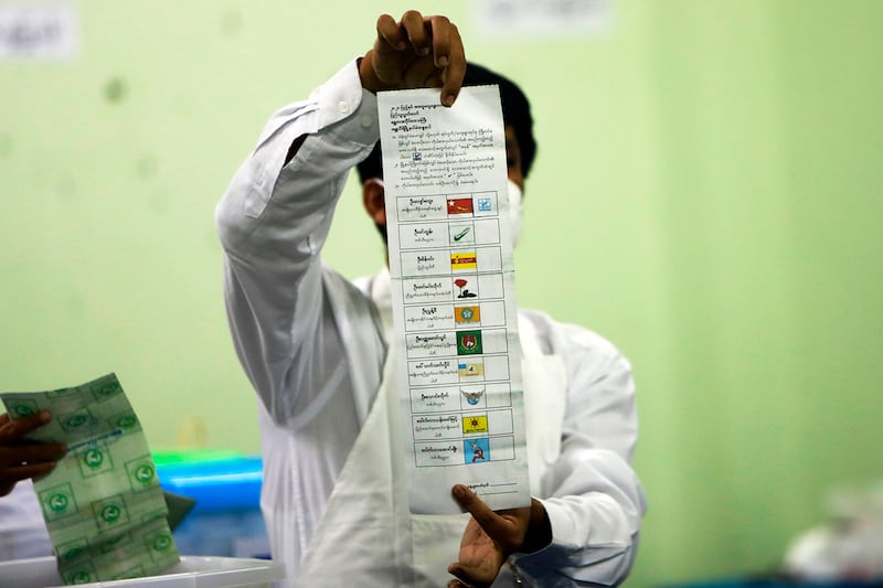 An official with the Myanmar Union Election Commission counts ballots at a polling station in Naypyidaw on Nov. 8, 2020.