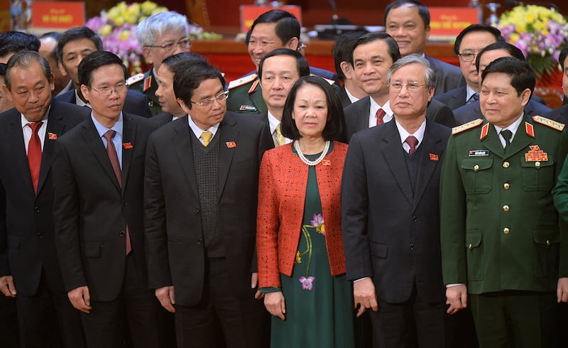 Newly elected Politburo members (L to R) Truong Hoa Binh, Vo Van Thuong, Pham Minh Chinh, Truong Thi Mai, Tran Quoc Vuong and Ngo Xuan Lich pose on the podium along with other new members of the Vietnam Communist Party\'s central committee at the closing ceremony on the final day of the 12th National Congress of Vietnam\'s Communist Party in Hanoi on January 28, 2016. Vietnam\'s top communist leader Nguyen Phu Trong was re-elected on January 27 in a victory for the party\'s old guard which some fear could slow crucial economic reforms in the fast-growing country.      AFP PHOTO / POOL / HOANG DINH Nam (Photo by HOANG DINH NAM / POOL / AFP)