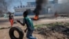 FILE - A protester rolls a tire to burn during a protest in the Choupal neighborhood of Maputo, Mozambique, Nov. 15, 2024. 