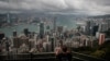 FILE - A visitor sets up his camera in the Victoria Peak area to photograph Hong Kong's skyline, Sept. 1, 2019. 