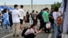 FILE - China's slowing economy has left millions of young people competing for an ever-slimming raft of jobs and facing an increasingly uncertain future. In this photo taken Aug. 26, 2022, a woman uses her phone during a job fair in Beijing. 